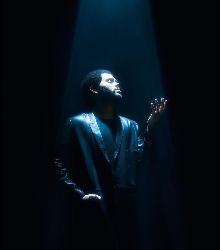 The Weeknd en reflector azul mirando hacia arriba